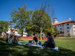 Three students sitting on quad